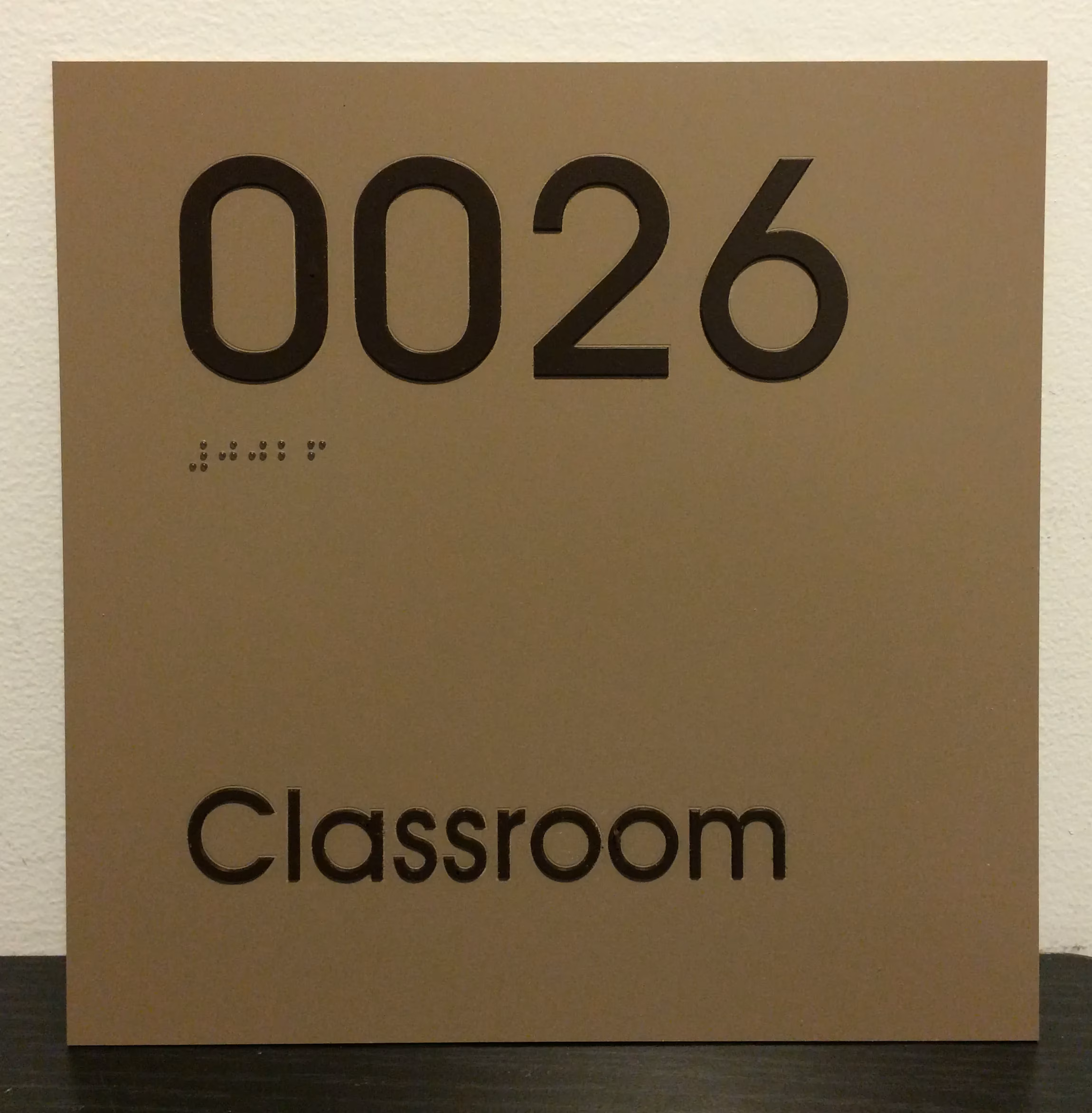 Gold acrylic ADA room sign with black text