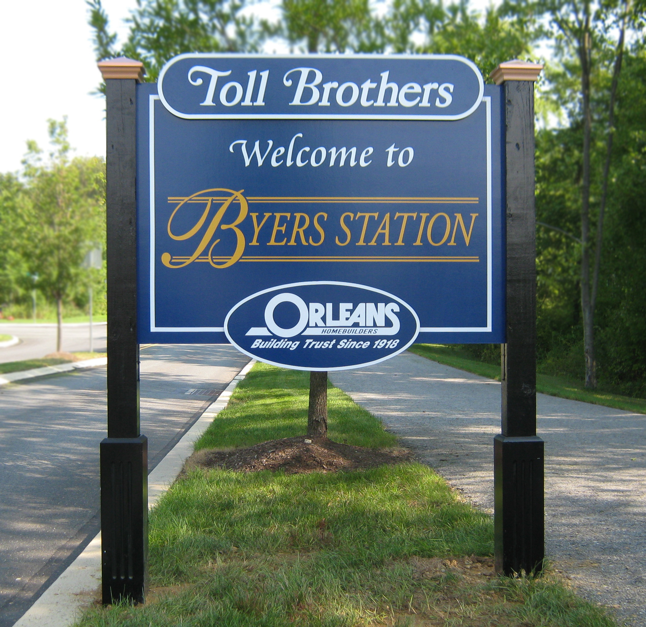 Layered MDO sign mounted between two black posts