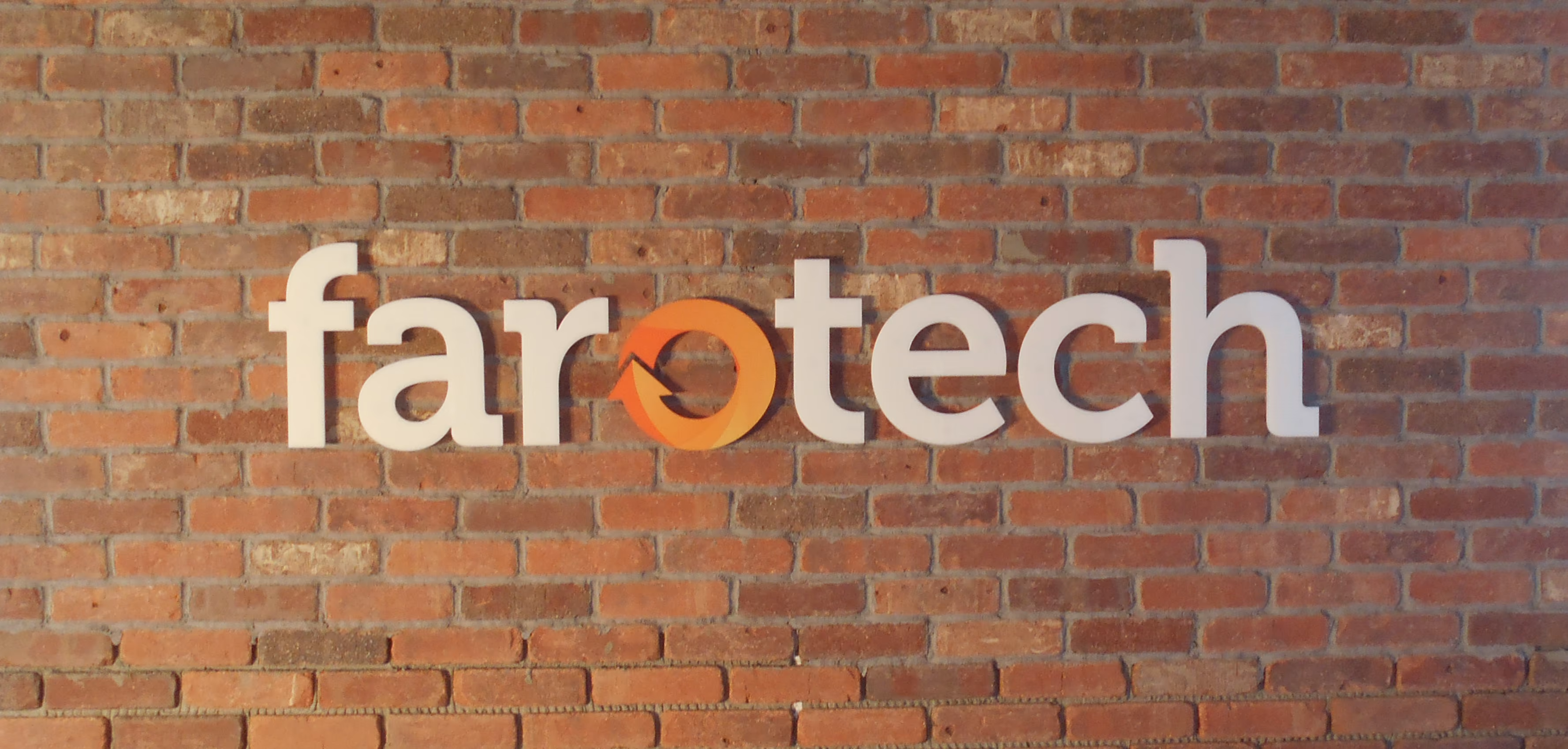 White acrylic dimensional letters with vinyled faces mounted on a brick wall
