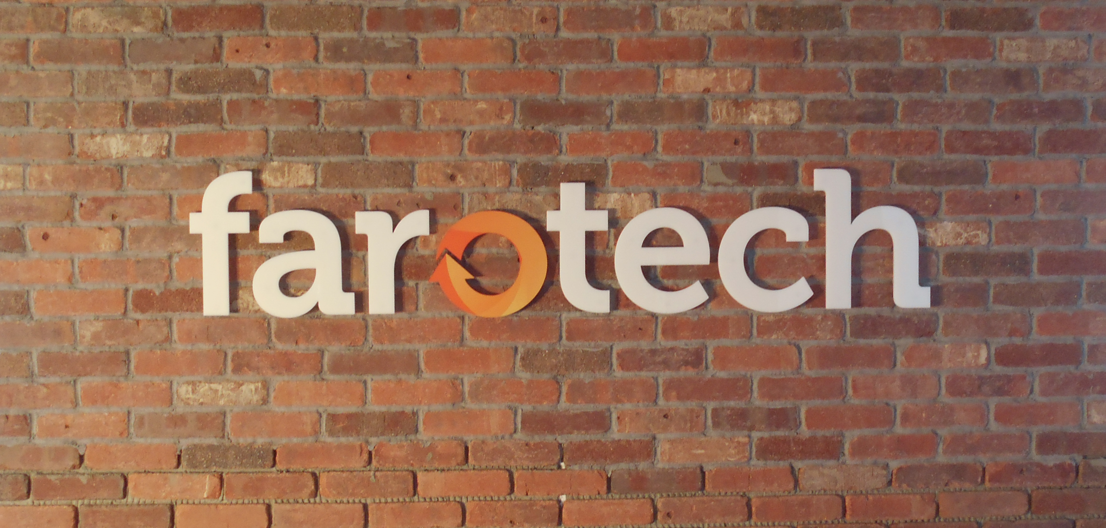 White acrylic dimensional letters with vinyled faces mounted on a brick wall