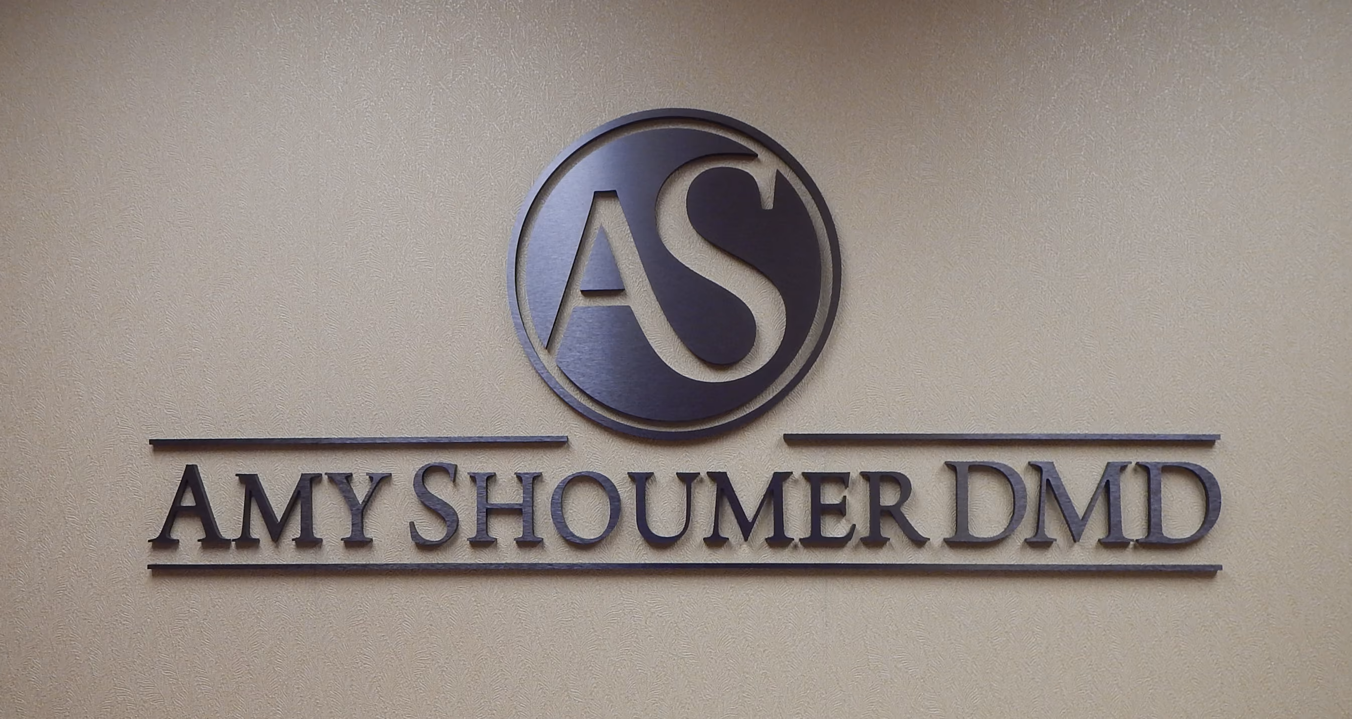 Brushed metal dimensional letters and logo mounted on a interior wall