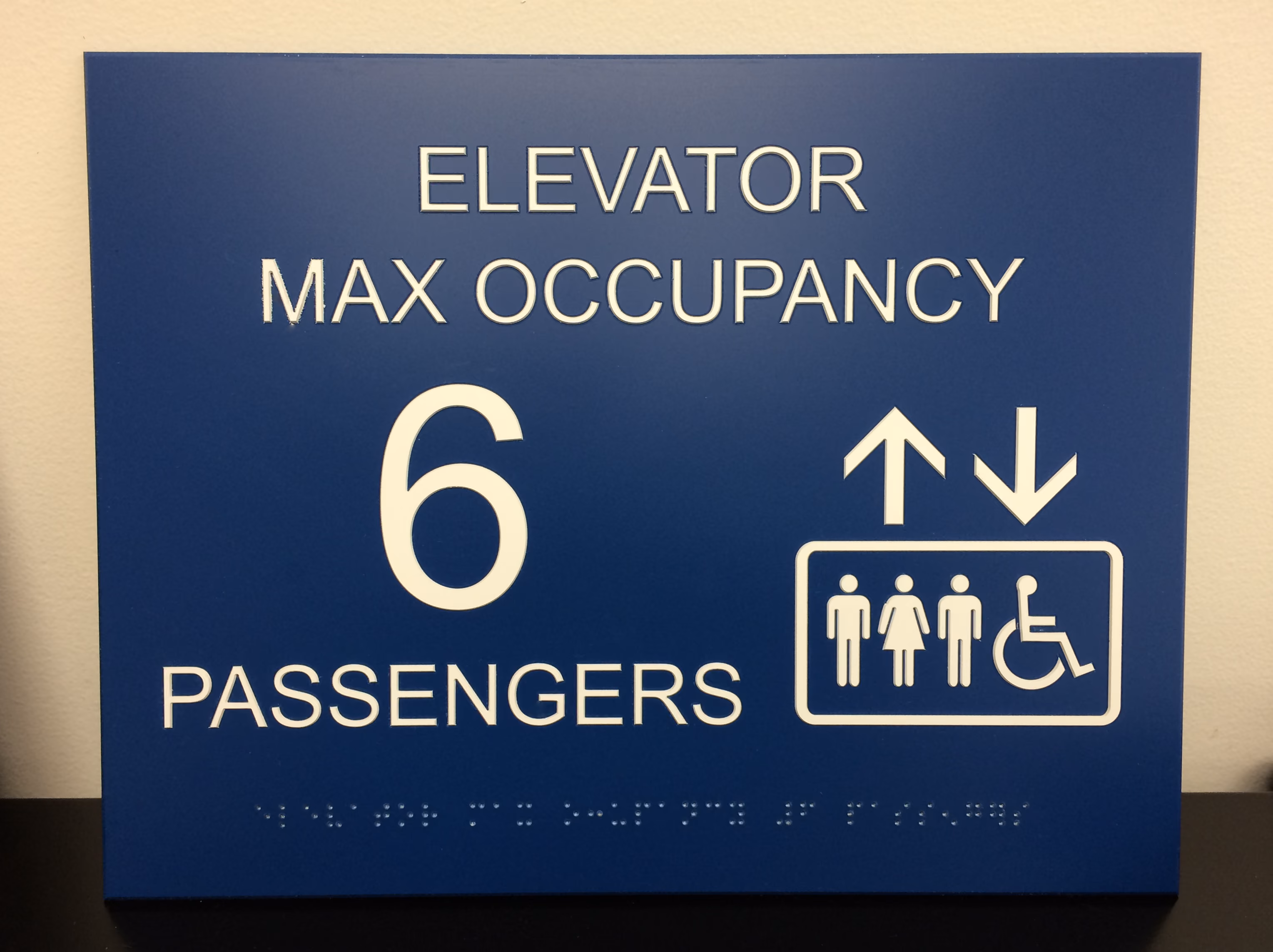 Blue and white ADA elevator sign