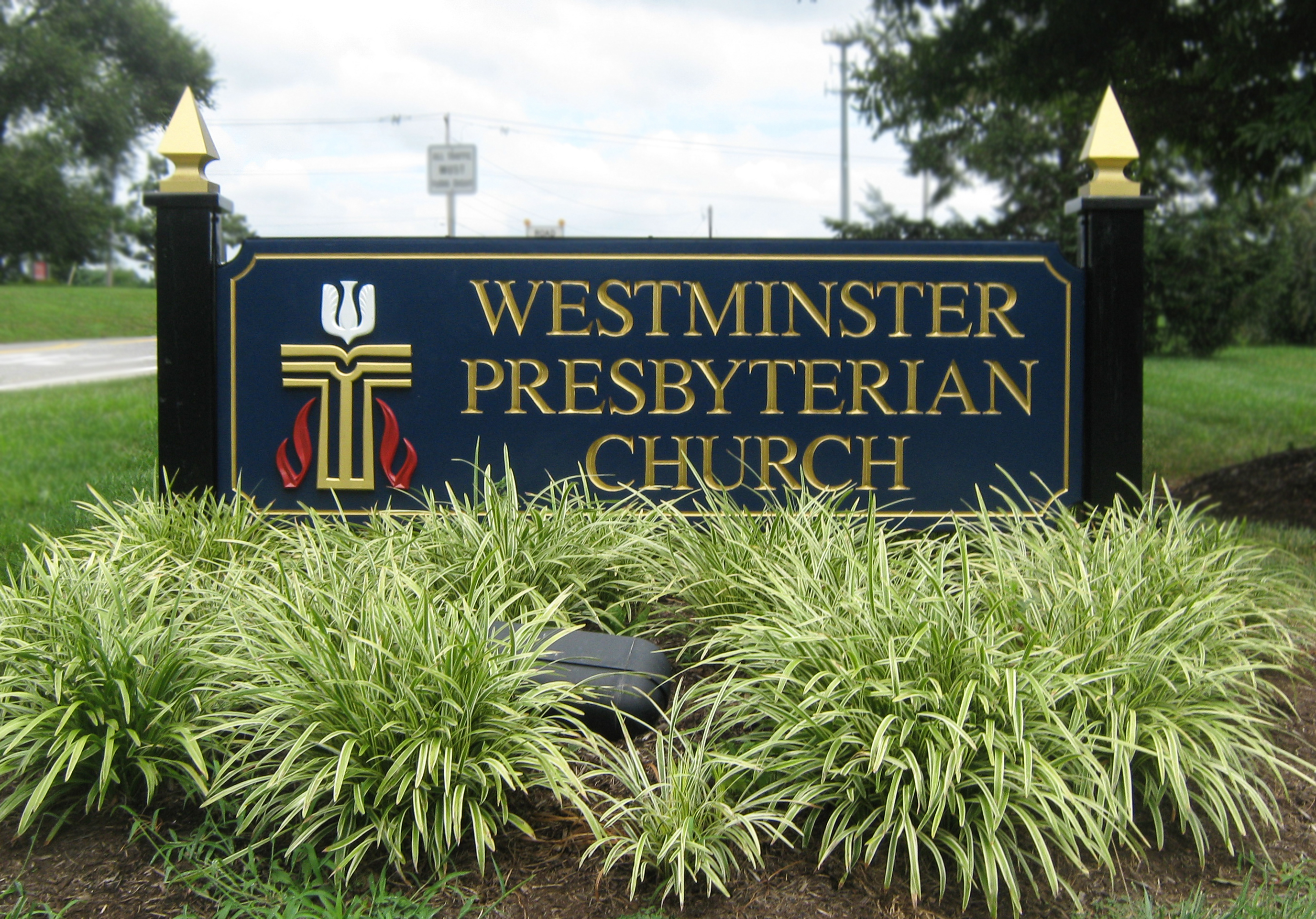 Carved HDU monument sign installed on two black posts with gold finials