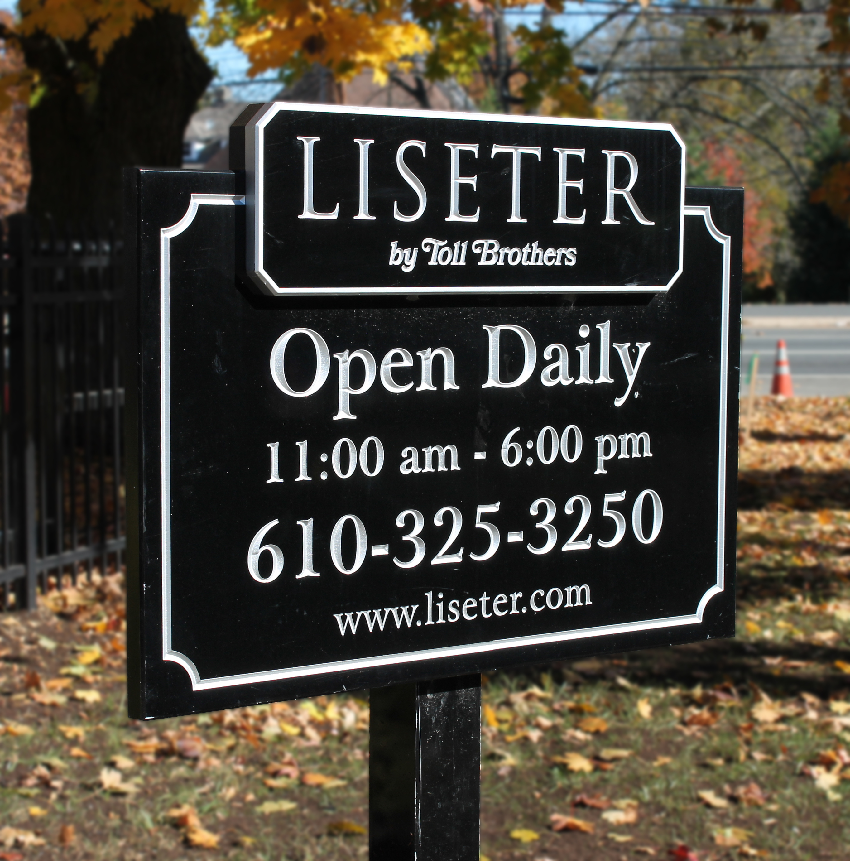 Layered carved HDU signs mounted on a black post