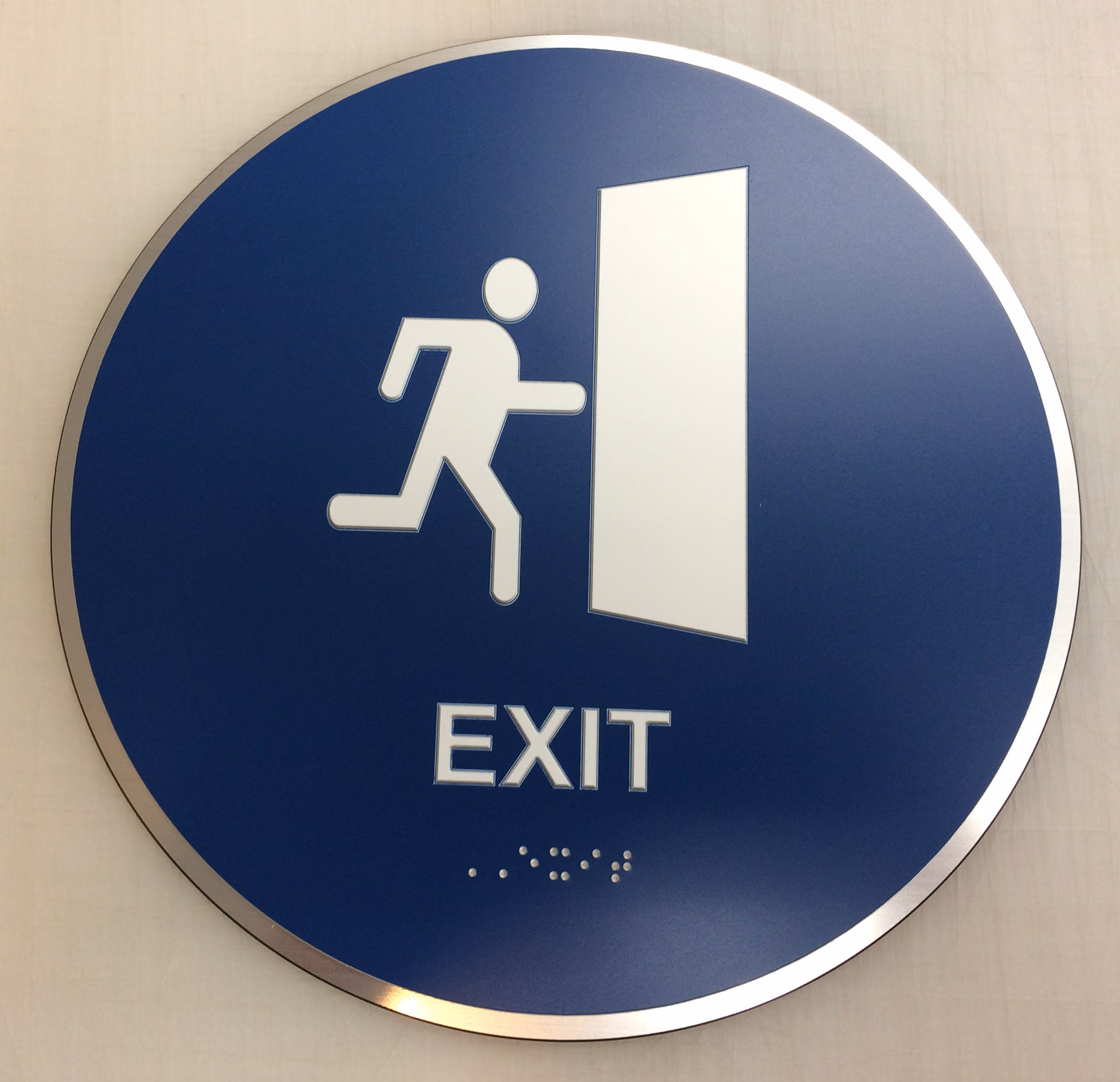 Circular ADA Sign made from blue acrylic on an aluminum backer
