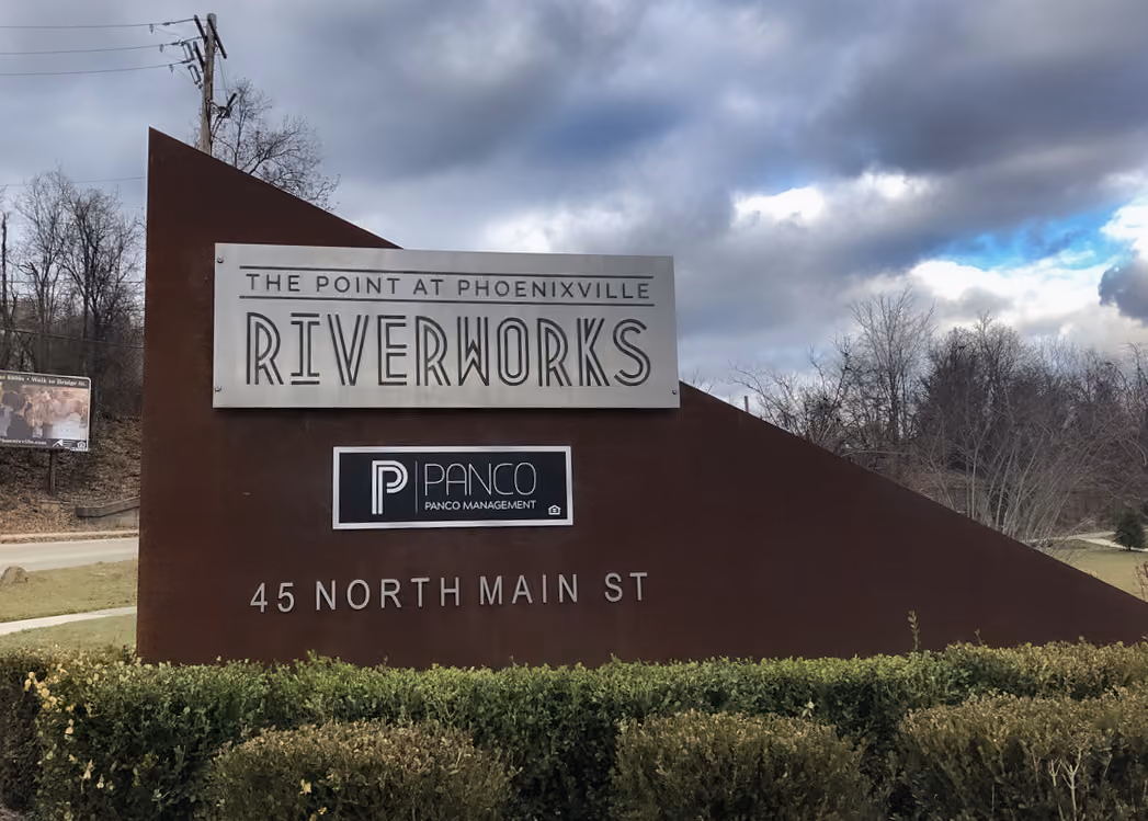 Custom triangle-shaped monument sign with a routered aluminum panel