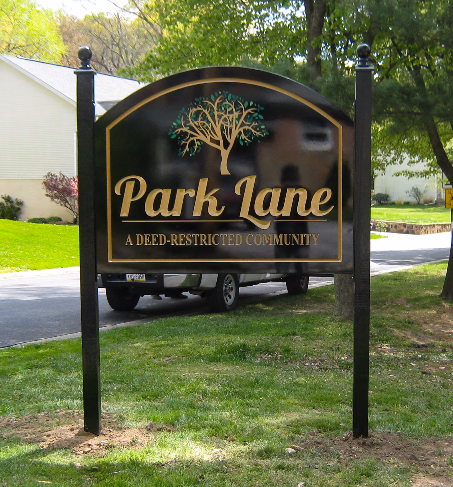 Three-color carved HDU sign installed between two black posts