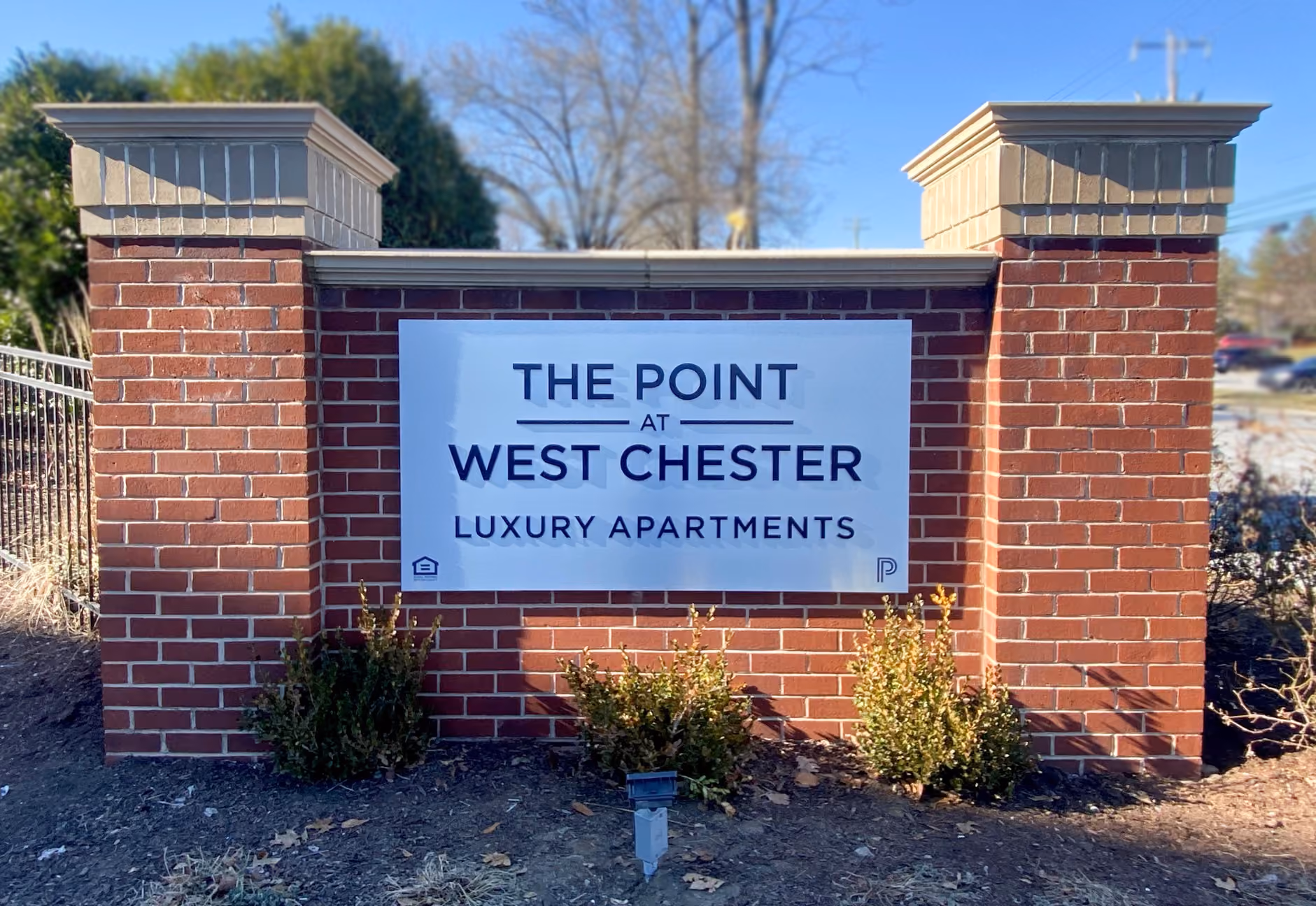 Brick monument framing a painted, aluminum sign with dimensional letters