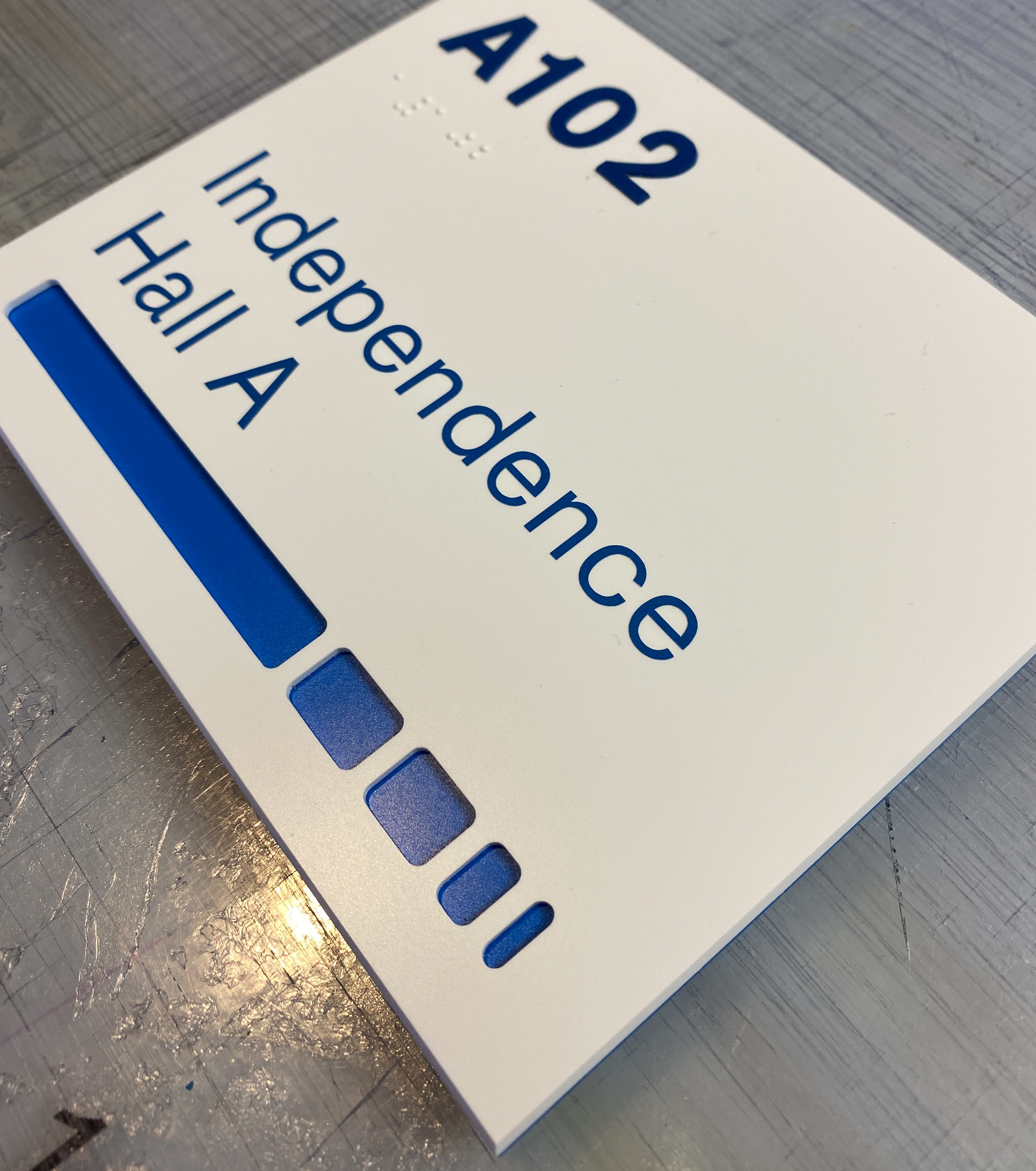 Custom ADA room sign with blue applique on white acrylic