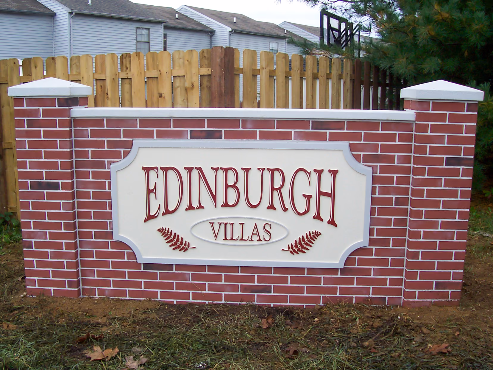 Carved HDU sign mounted on a brick monument base