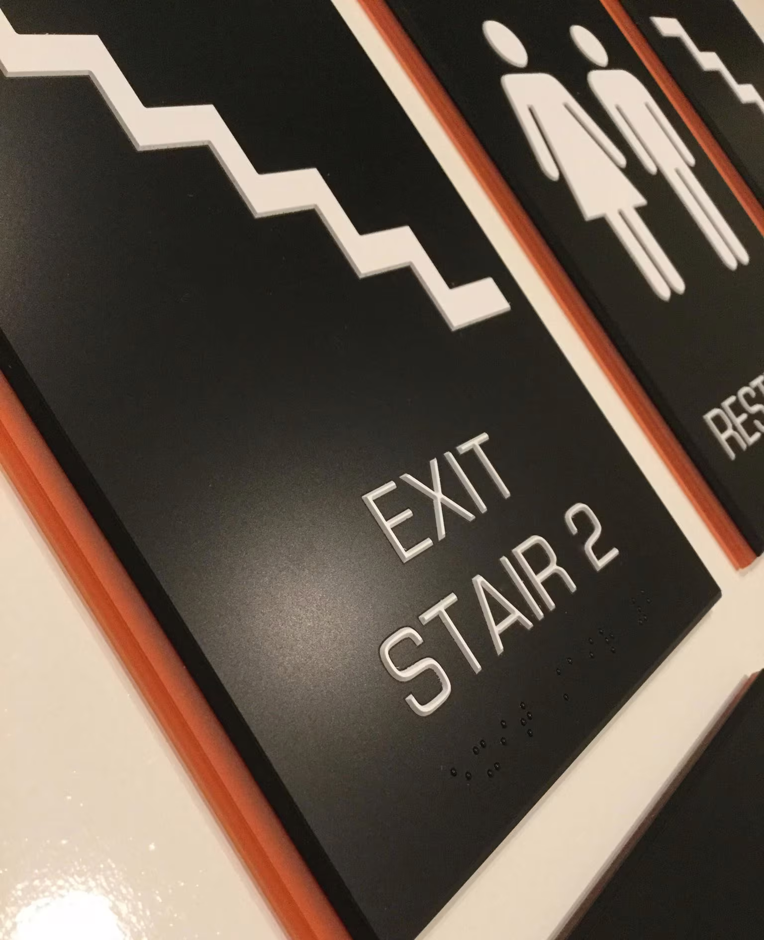 Custom ADA stair and restroom signs on custom-colored backer