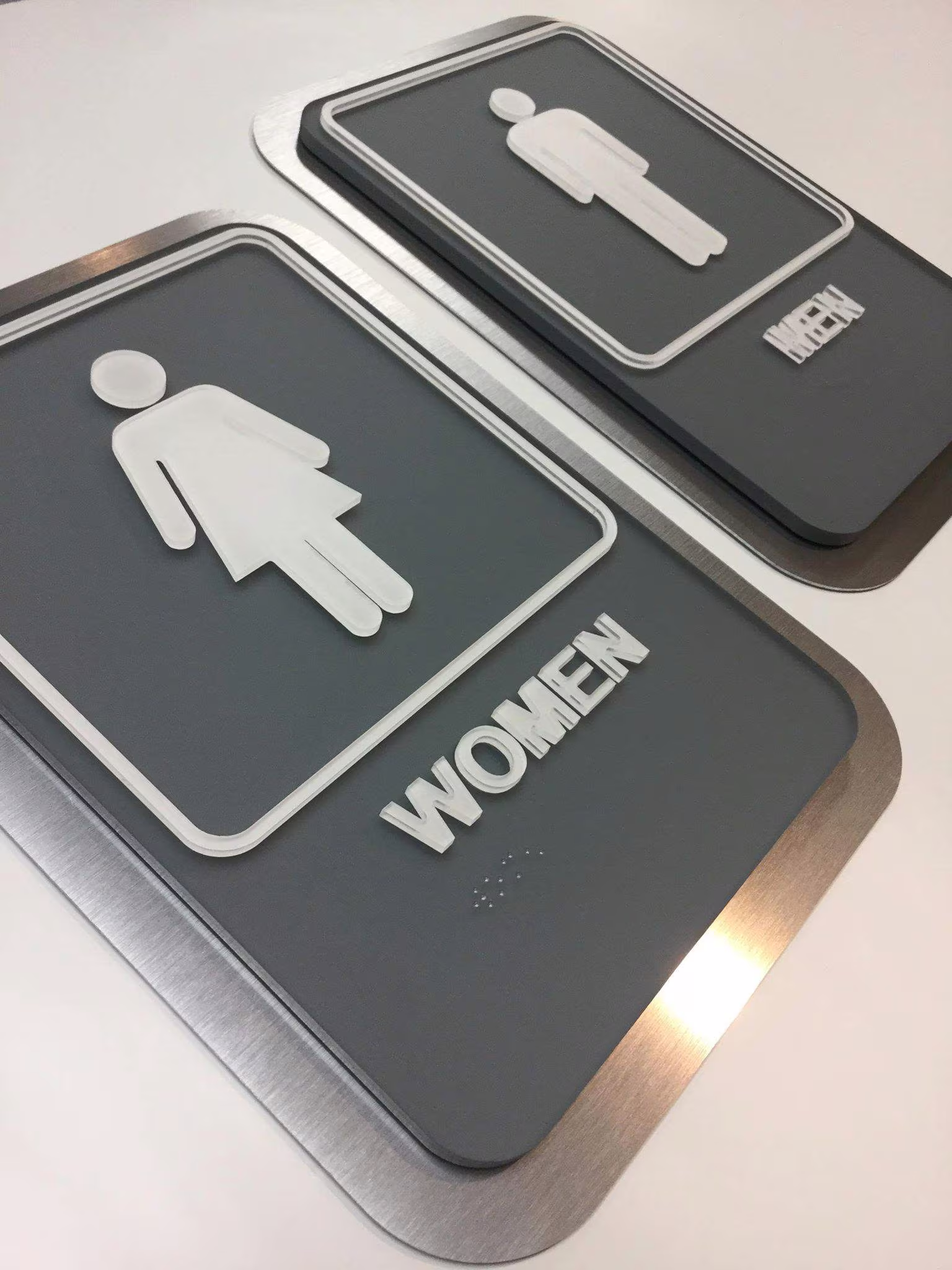 Custom ADA restroom signs with white applique on black acrylic