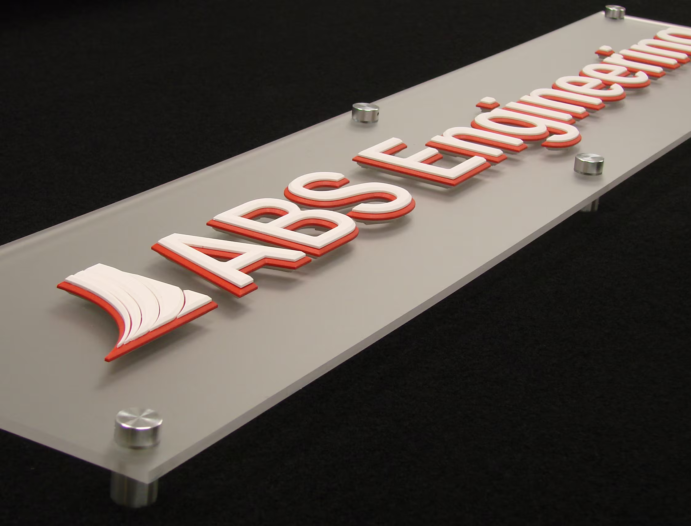 Layered white and red acrylic cut into dimensional letters and logo