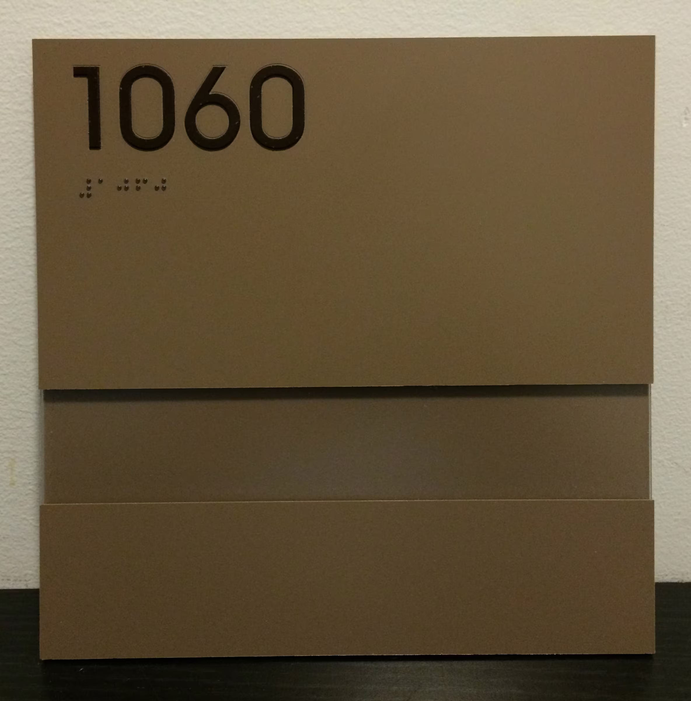 Custom, gold-toned acrylic ADA room sign