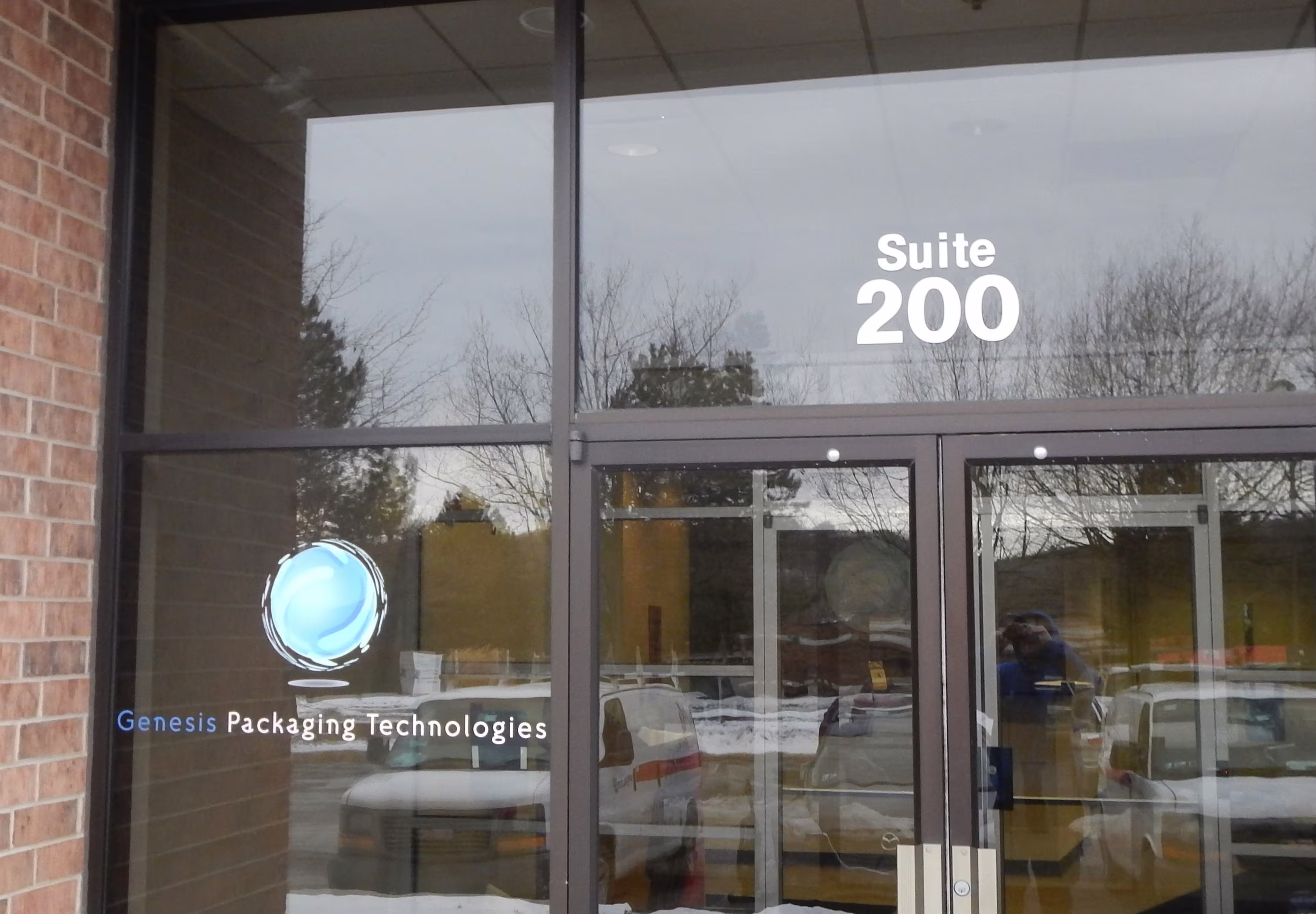 Company name and logo lettered to the left of glass entrance doors