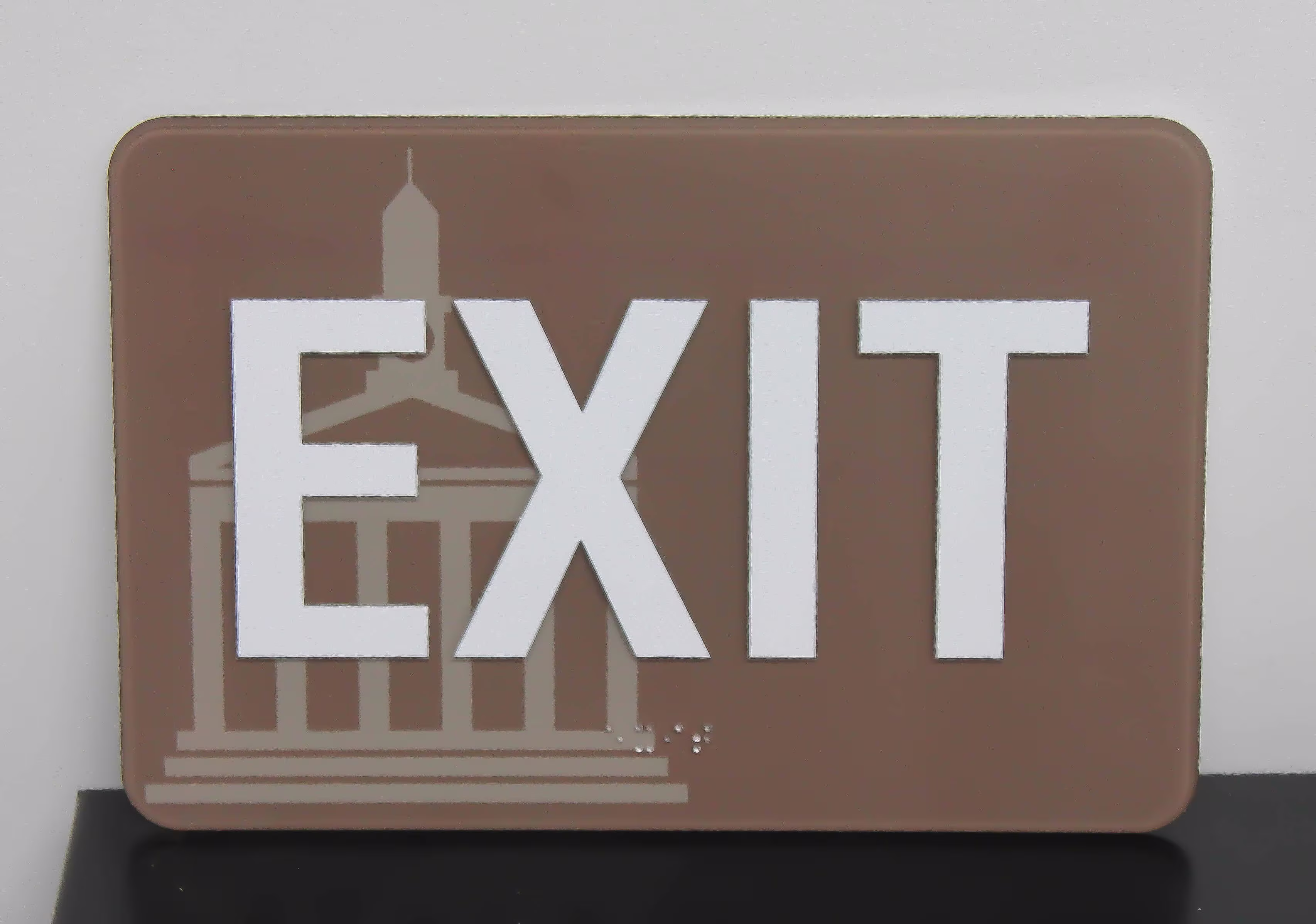 ADA exit sign on clear acrylic with a custom-printed graphic on the second surface