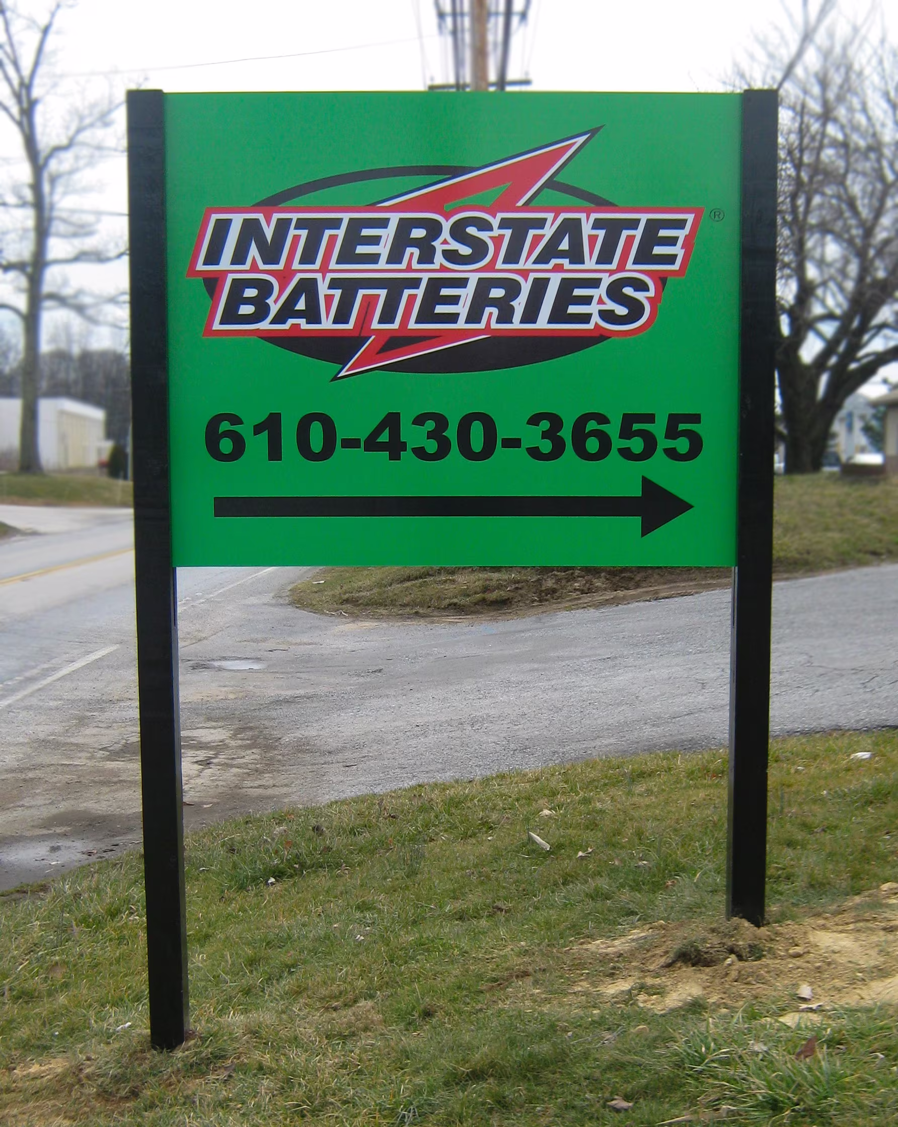 Green sign with viny lettering mounted between two black posts