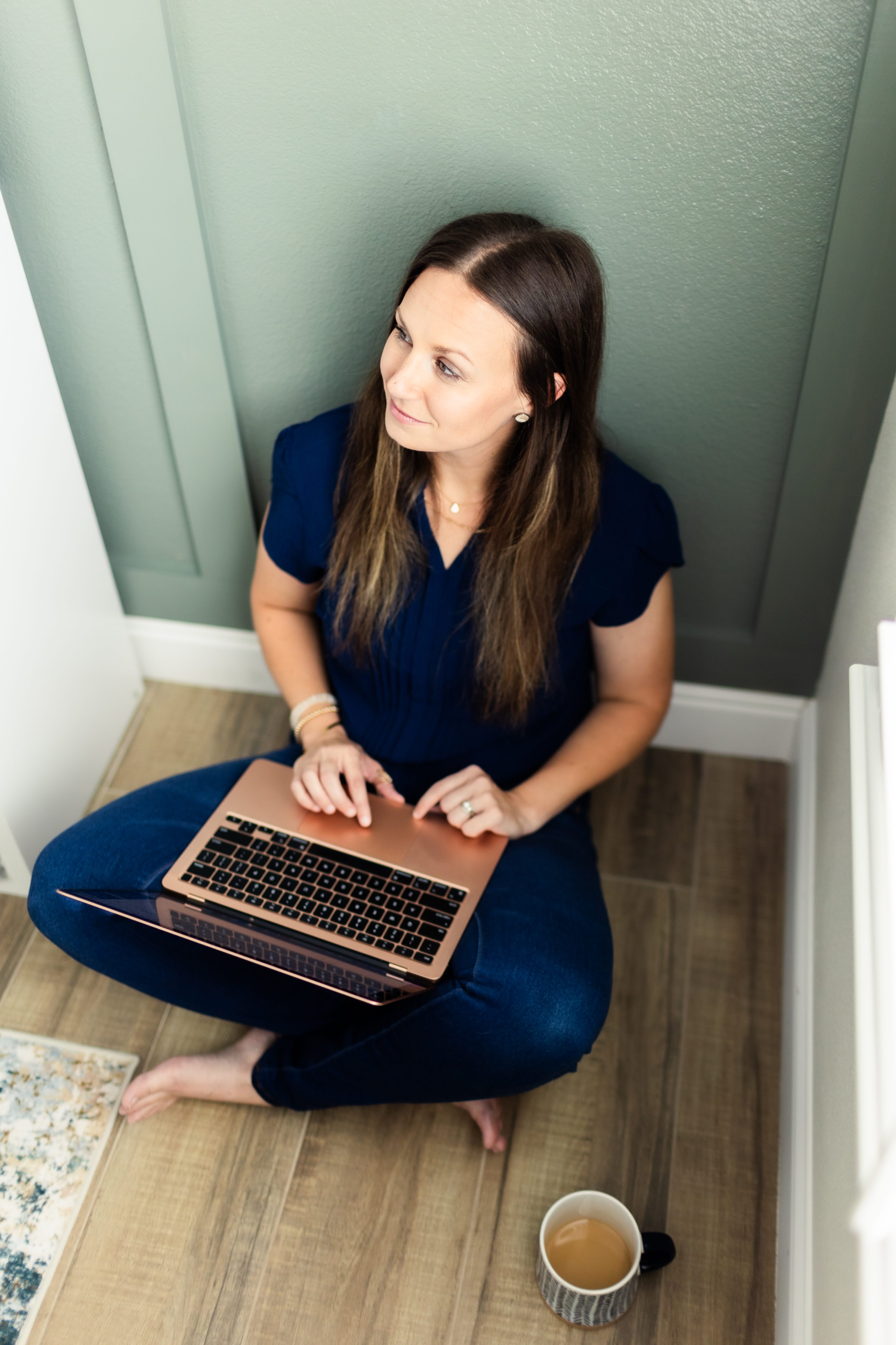 Lisa Autry sitting at her laptop, looking thoughtfully to the side.