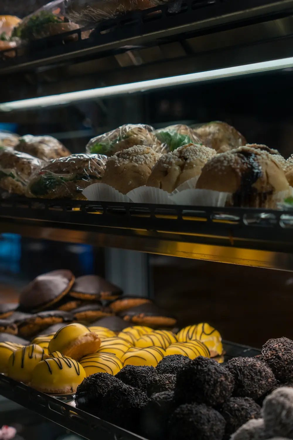 Bakverk i glasmonter på Åby Konditori med arraksbollar och biskvier