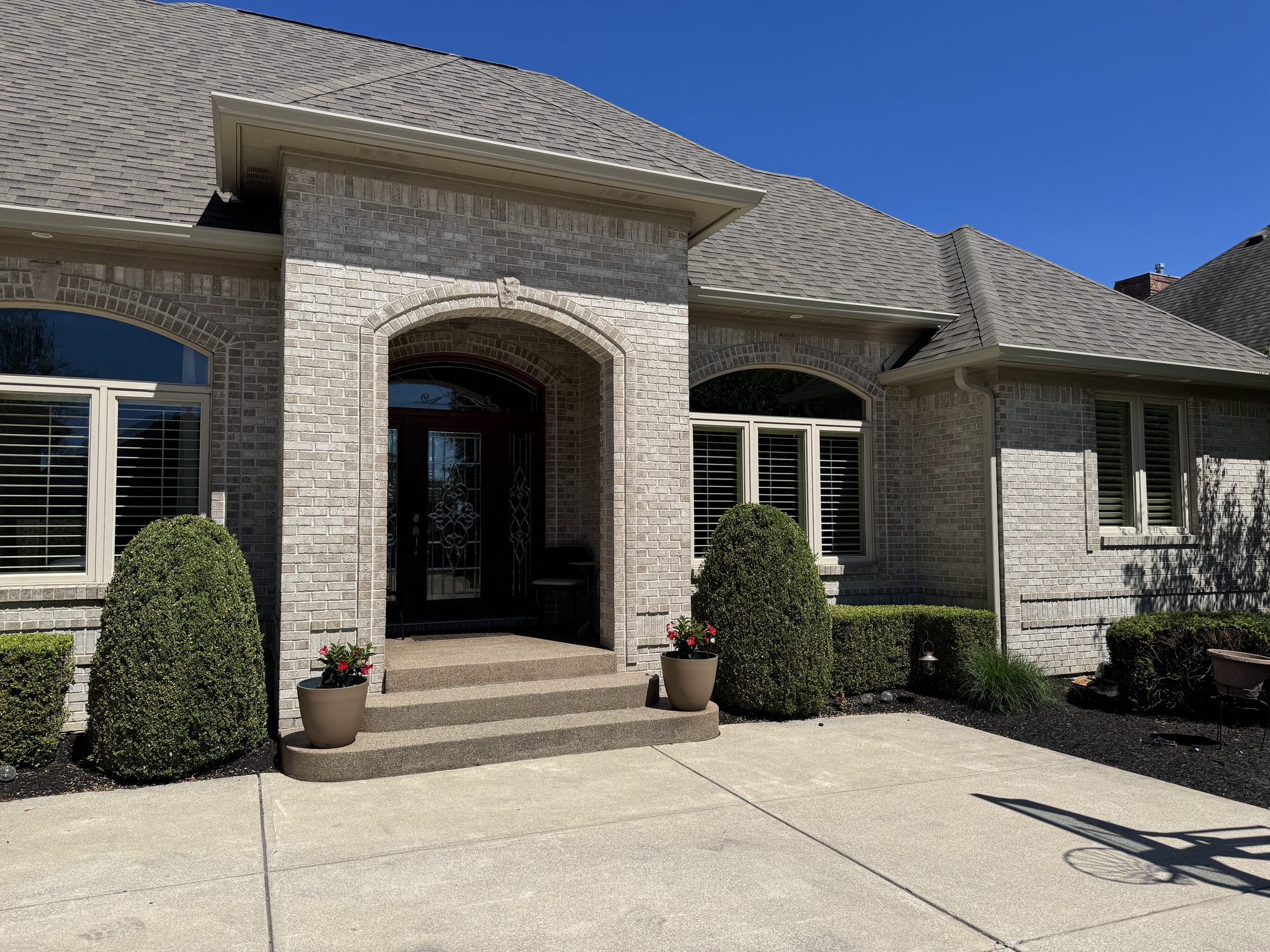 Suburban two-story home with siding, roofing, and a large lawn