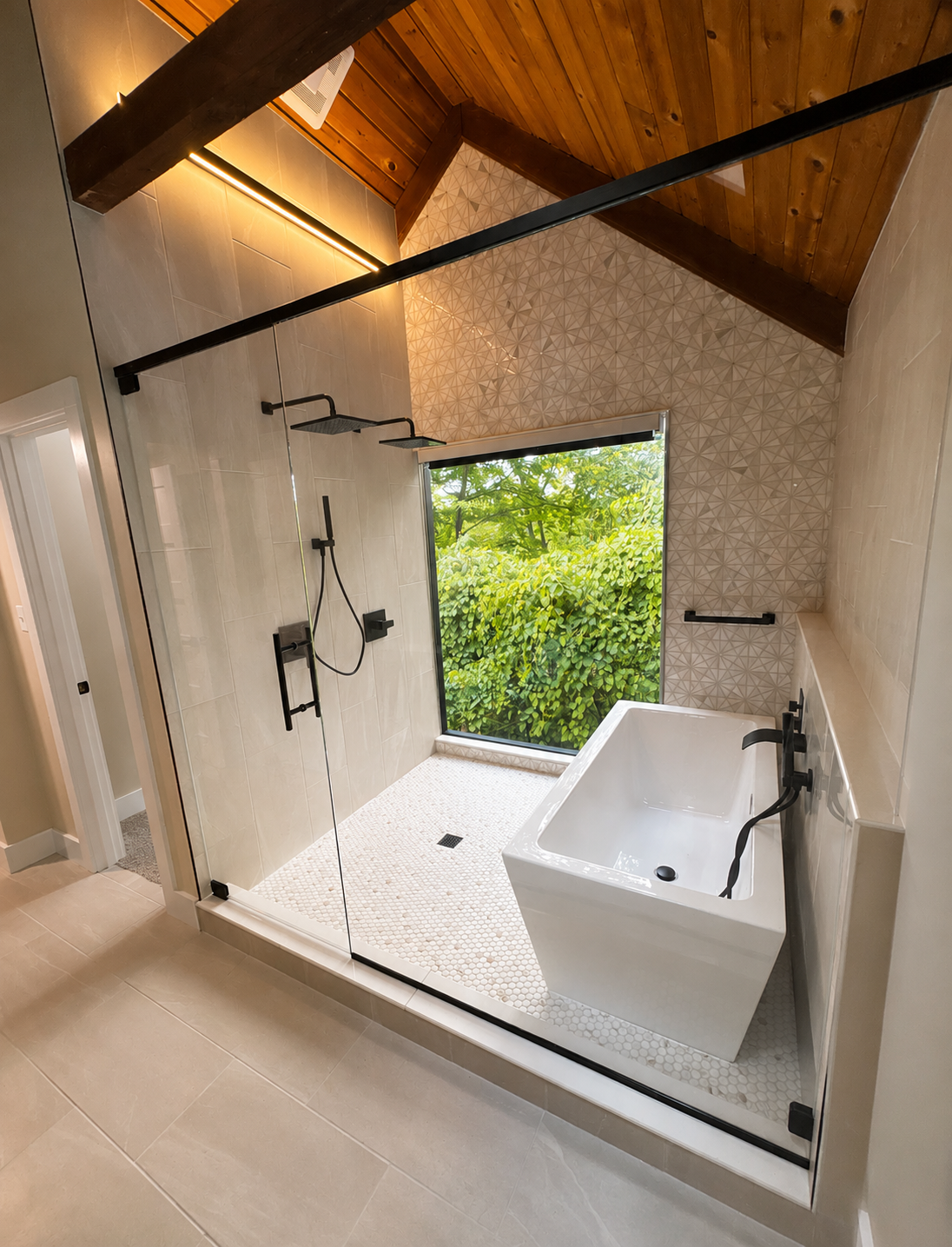 Spa bathroom with glass-enclosed walk-in shower, freestanding tub, and vaulted wood ceiling by JCZ Residential in Indianapolis, Indiana