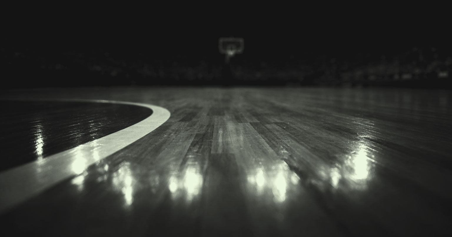 Up close image of a hardwood basketball court