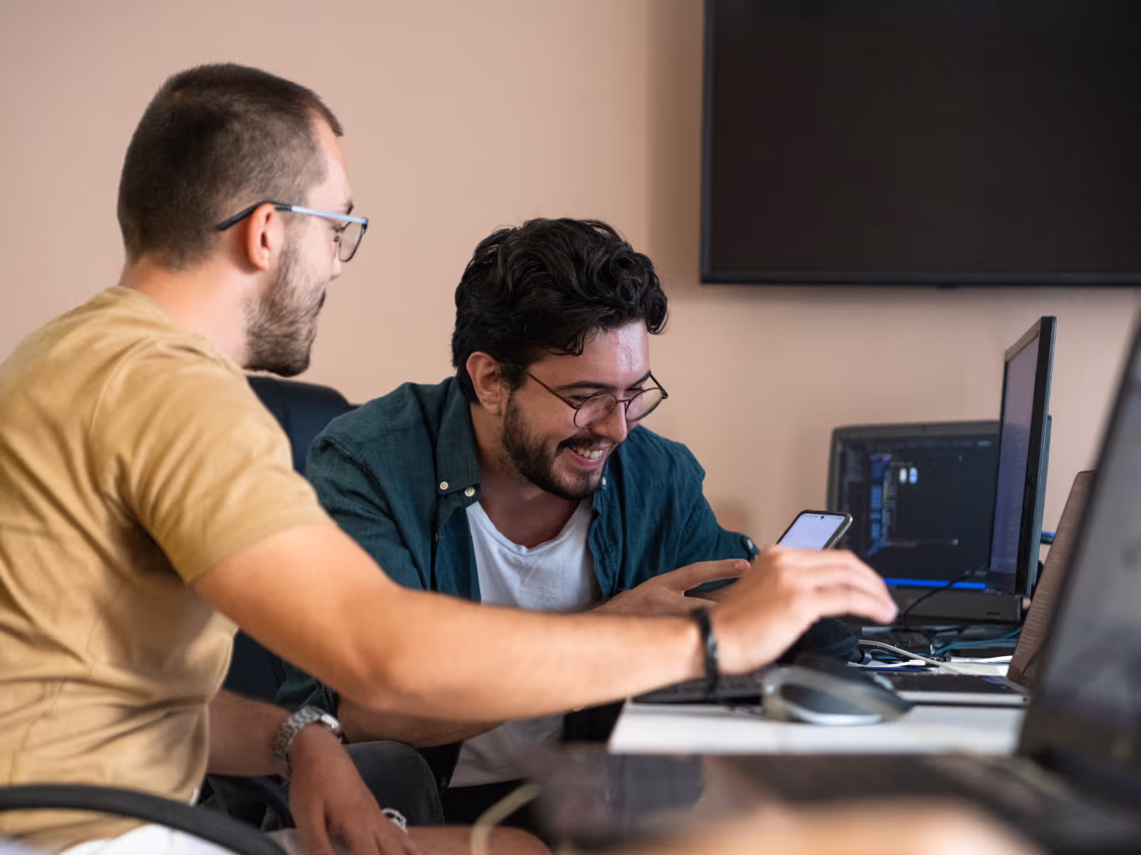 Dois desenvolvedores trabalhando e sorrindo.