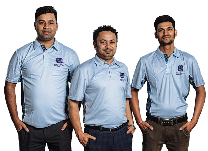 Three smiling workers wearing blue uniforms standing side by side.