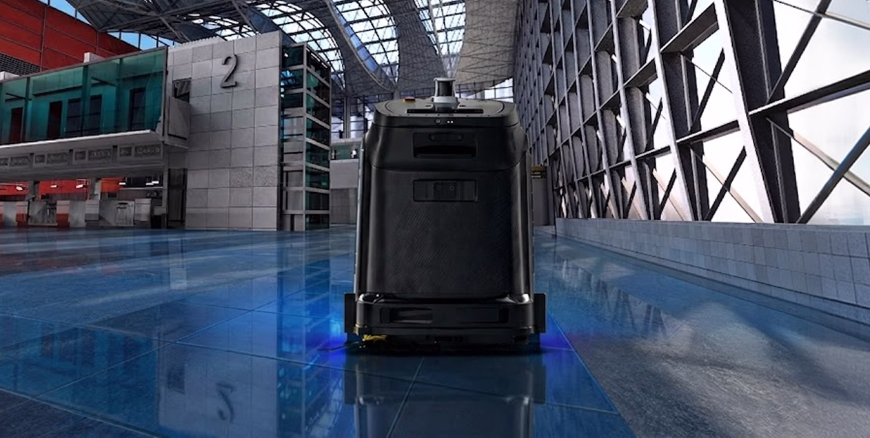 Autonomous floor-cleaning robot operating in a spacious modern building with blue reflective tiles.