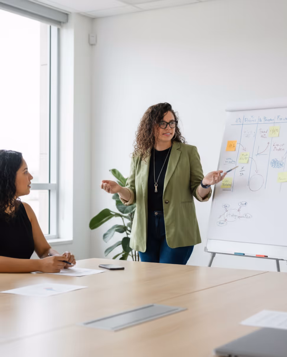 Dos personas mirando una pizarra discutiendo el contenido