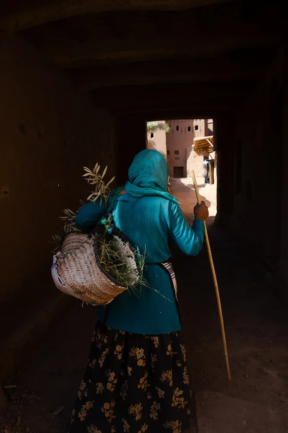 A woman in a blue jacket carrying a basket.