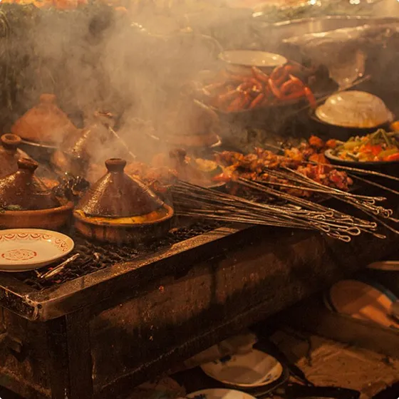A bunch of food is cooking on a grill.