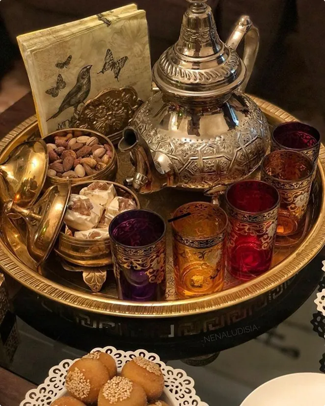 A tray with a tea pot, cups, and cookies on it.