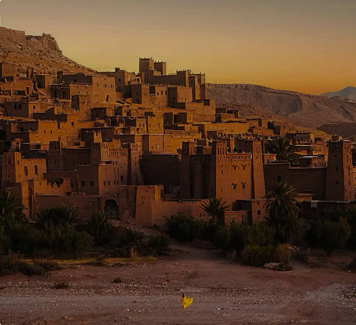 A village in the desert with a mountain in the background.