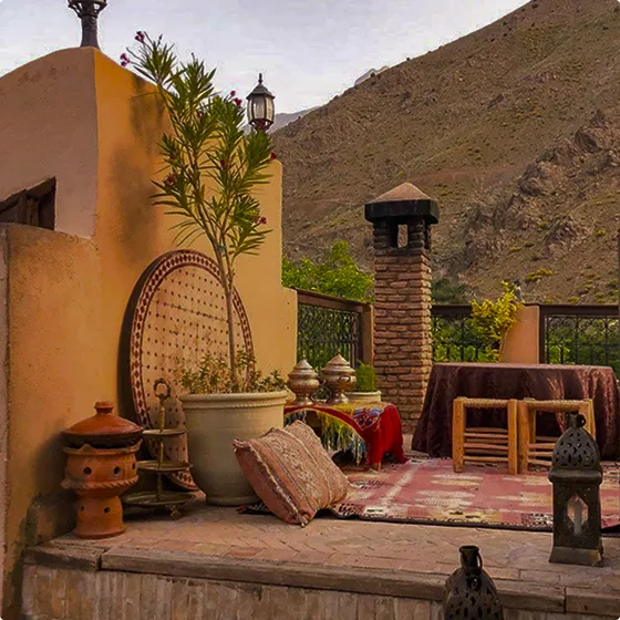 A patio with a lot of furniture and a mountain in the background.