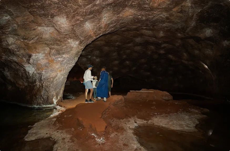 A couple of people that are standing in a cave.