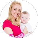 Lächelnde Frau mit langem blonden Haar hält ein Baby mit hellem Haar in weißem Strampler.