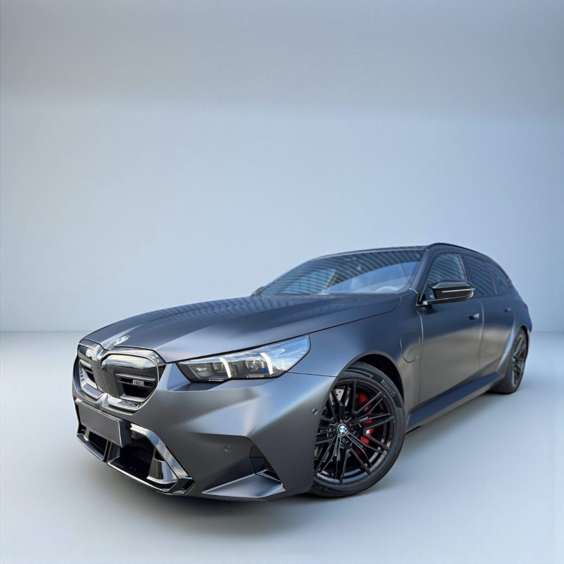 Matte black BMW M3 sedan angled to show front and side with black alloy wheels and red brake calipers.