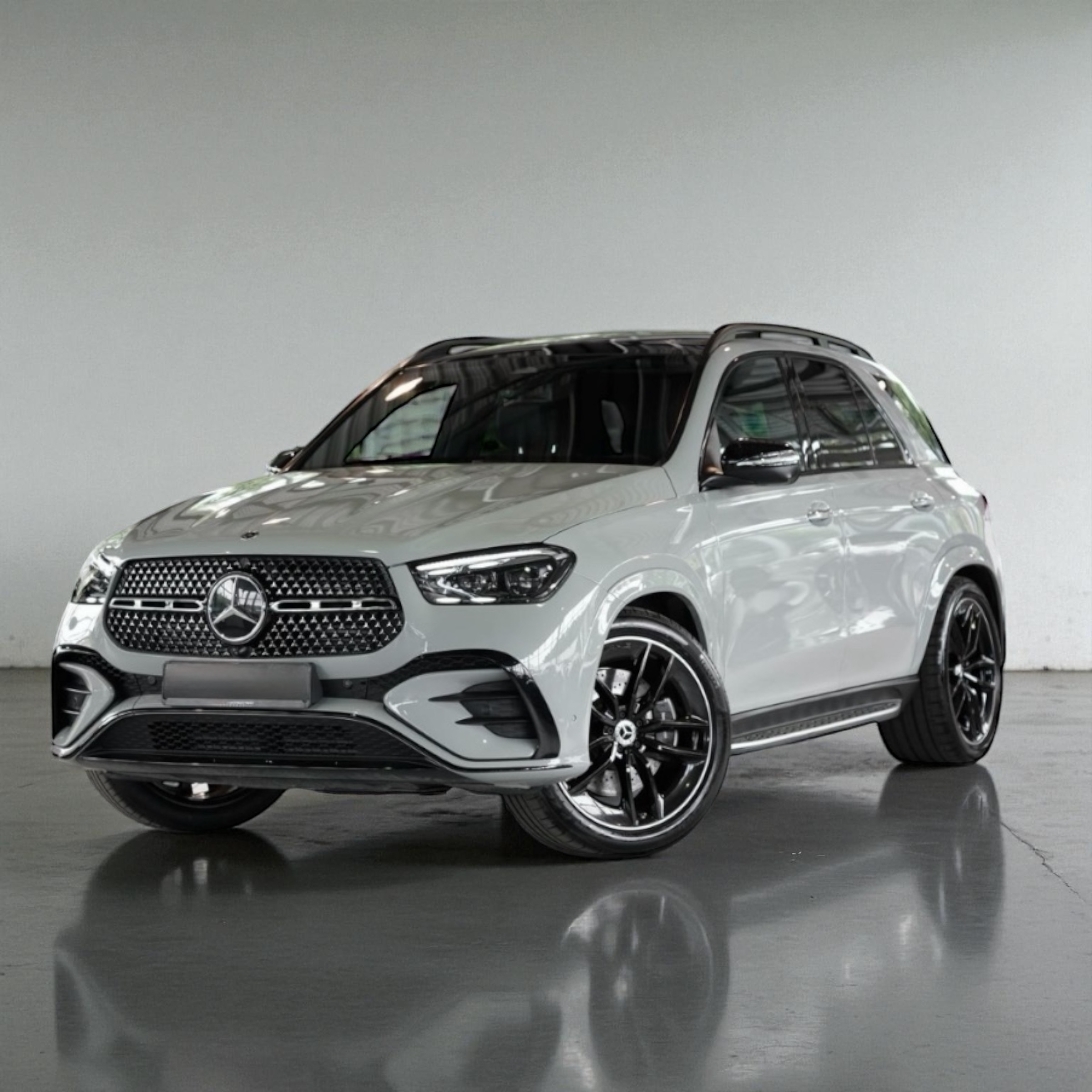 White Mercedes-Benz SUV parked indoors with black alloy wheels and a reflective floor.