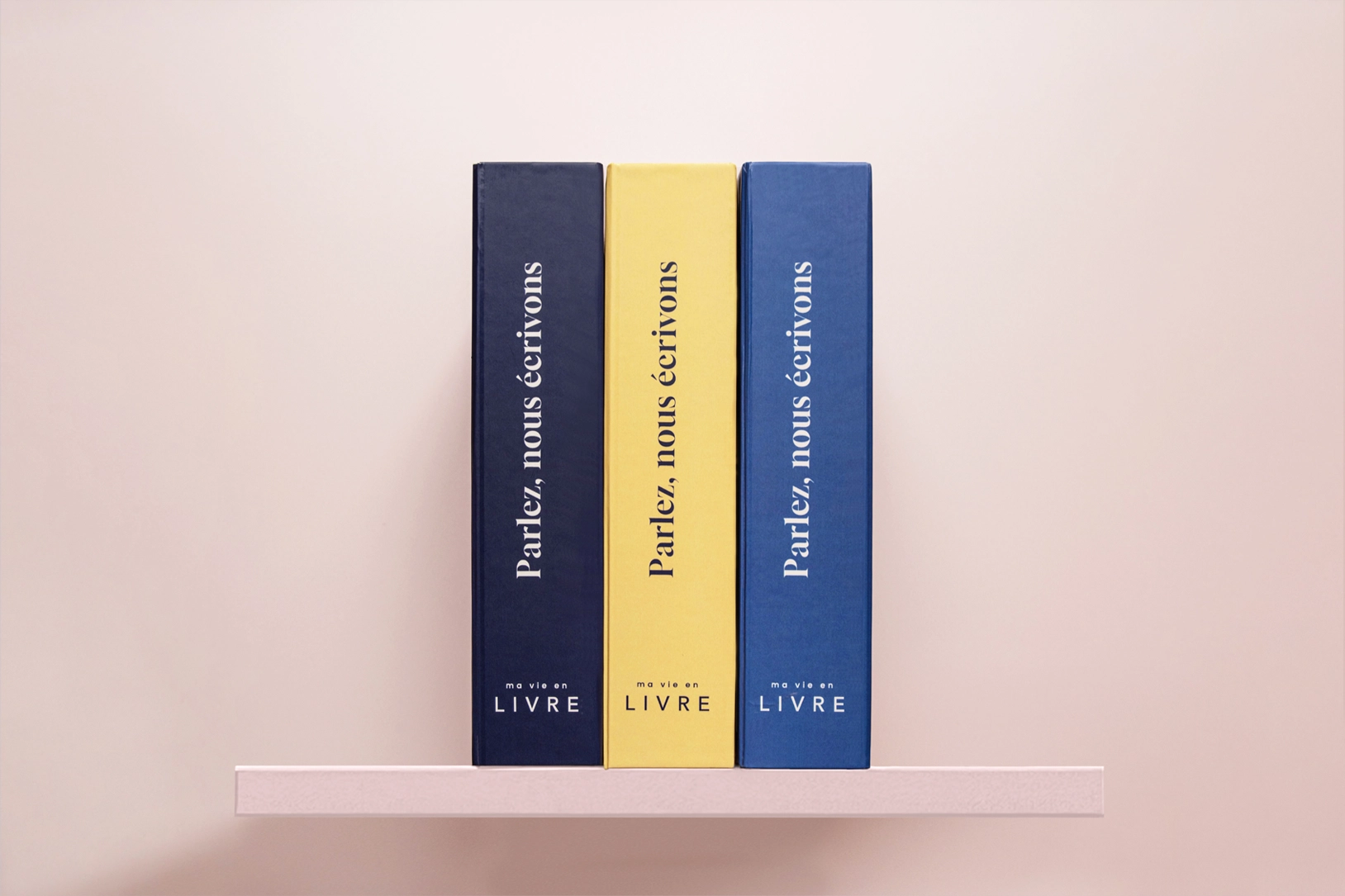 Trois livres souvenirs personnalisés Ma vie en LIVRE alignés sur une étagère, aux couvertures colorées et élégantes, avec l’inscription “Parlez, nous écrivons”