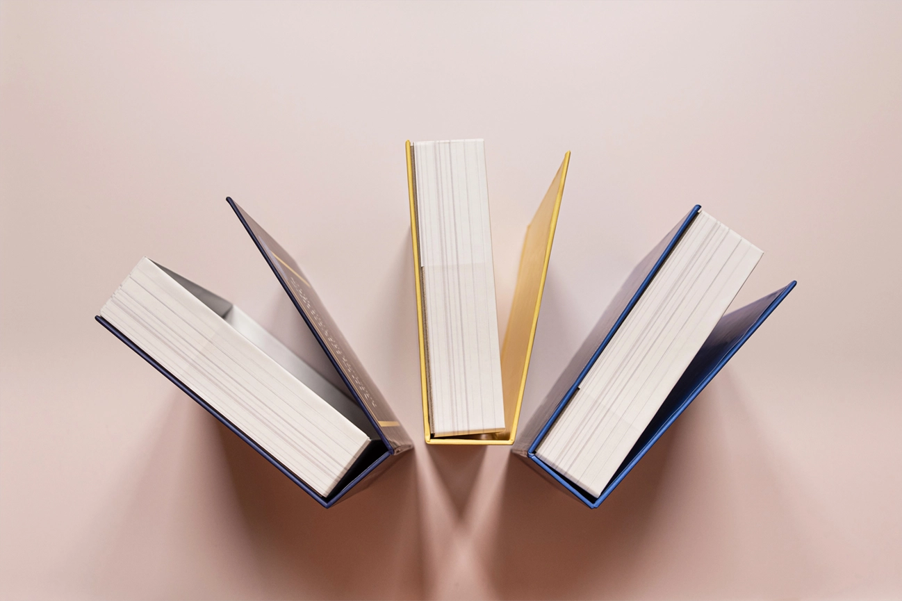 trois livres épais et rigides posés sur une table