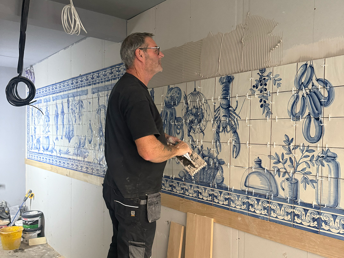 Fitting hand-painted blue and white azulejo tiles at Bar Douro Soho, Greek Street, London