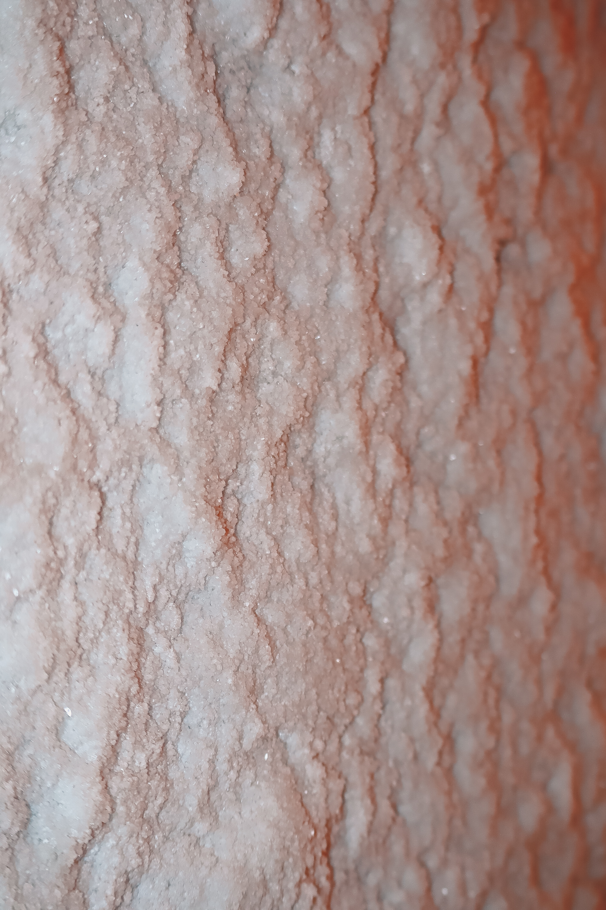 Close-up of translucent, crystalline salt or mineral granules with a textured, cubic appearance.