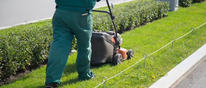 image of a gardener mowing the lawn