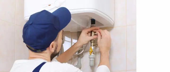 an image of of plumber fixing the geyser
