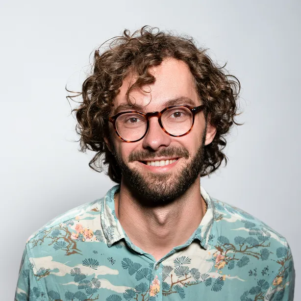 Young man with brown curly hair smiling
