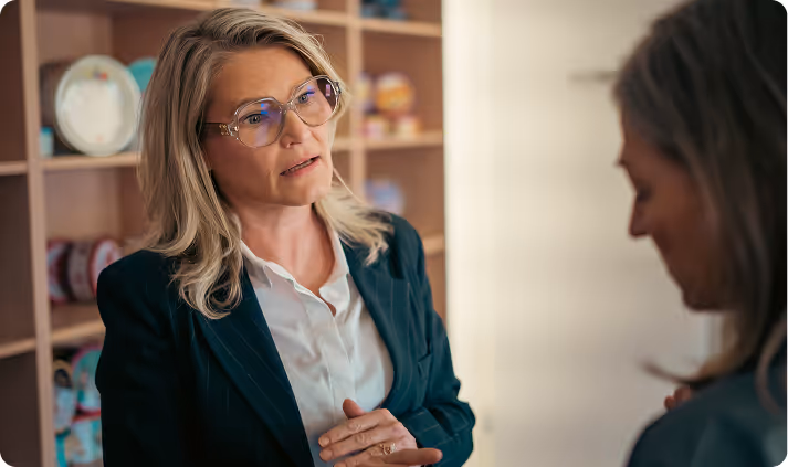 woman  in a suit with glasses talking