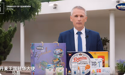 man in suit standing in front of some cookie boxes