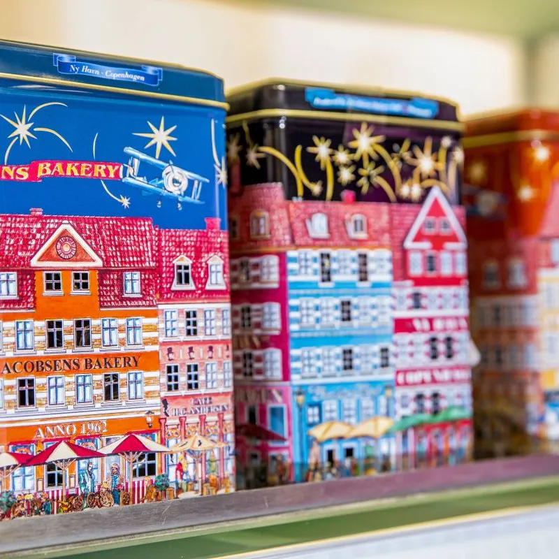 Cookie tins with colourful Copenhagen house designs on a shop shelf in Denmark