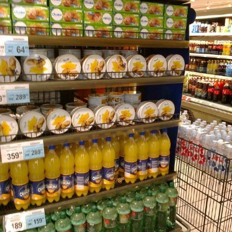Supermarket shelves with white Danish cookie tins and juices in Serbia